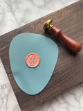 Turquoise silicon stamping mat. Mat can be used to create wax seals with wax seal adhesives to create stickers. Featured in this picture is the wildflower stamp, silver metallic marker and coral wax.